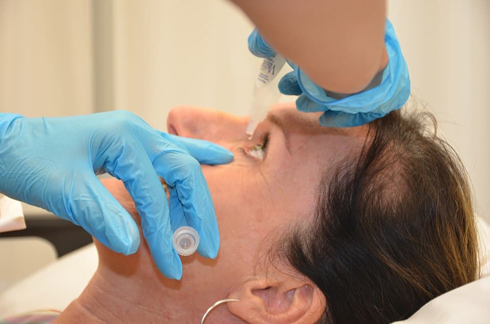 Health professional instilling an eye drop