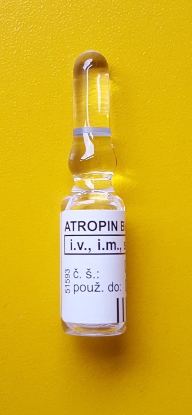 Ampoule of atropine solution against a yellow background
