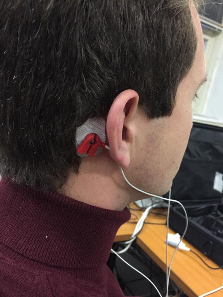 Electrode placed behind the ear during a visual evoked potential test.
